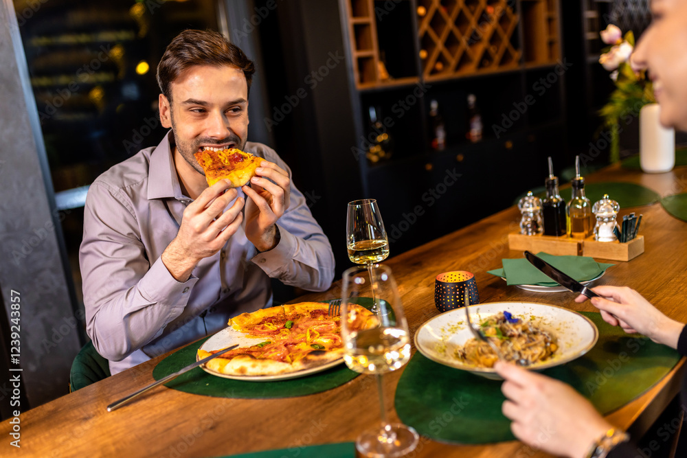 Young handsome man enjoys eating delicious pizza in restaurant. Young handsome man enjoys eating delicious pizza in restaurant.