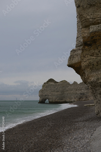 The soft, grey clouds and calm waters make for a peaceful winter scene at Etretats famous cliffs photo