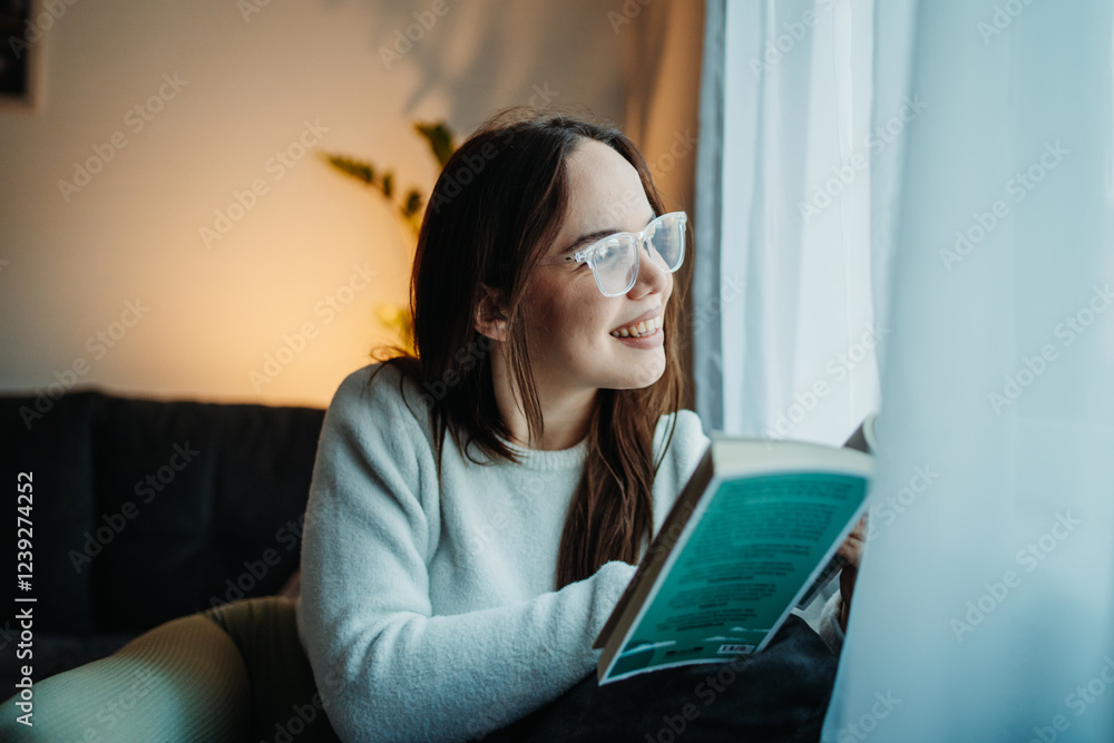 Young caucasian woman reading book or learning by the window Young caucasian woman reading book or learning by the window