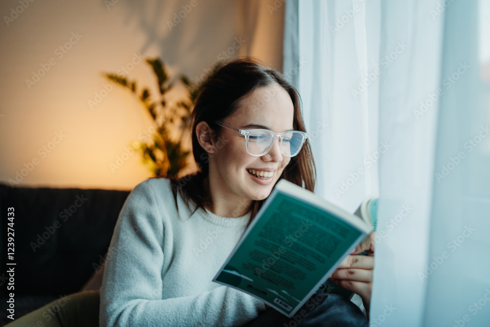 Young caucasian woman reading book or learning by the window Young caucasian woman reading book or learning by the window
