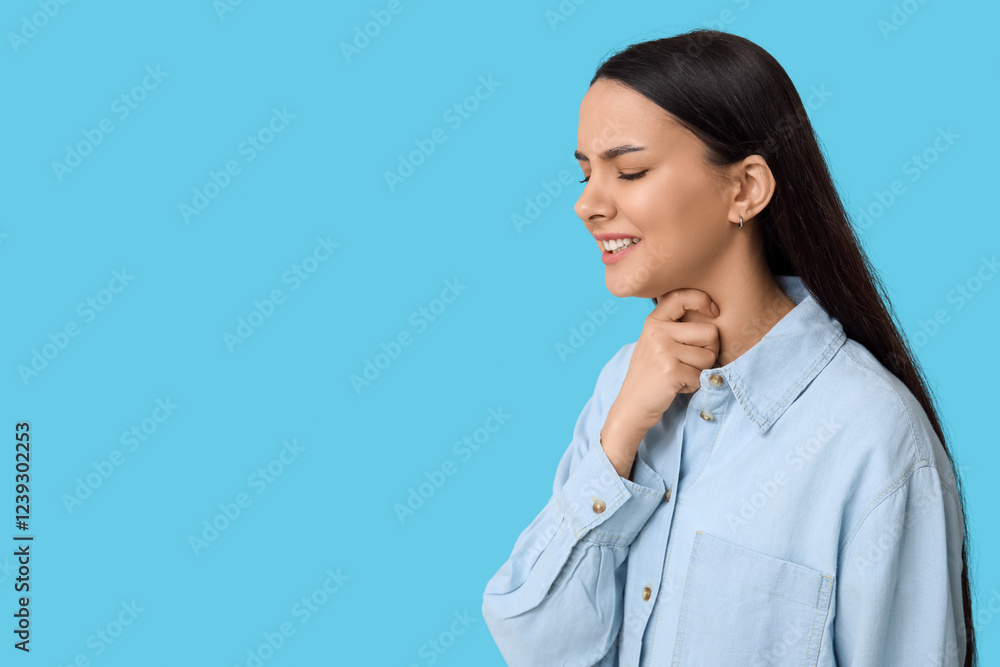 Beautiful young woman suffering from sore throat on blue background Beautiful young woman suffering from sore throat on blue background