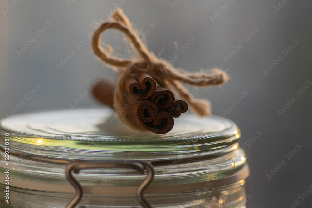 Fresh raw cinnamon sticks on glass dose bottle, sticks tied with one jute natural twines