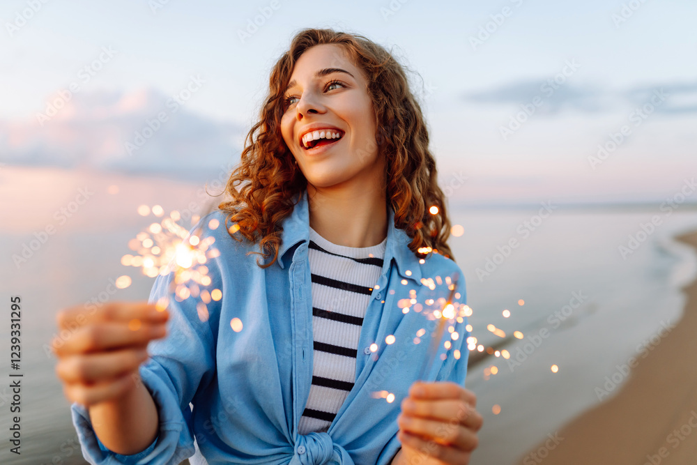 Teenage beautiful woman with sparklers on the beach at sunset. Summer holidays, party, vacation, relax and lifestyle concept. Teenage beautiful woman with sparklers on the beach at sunset. Summer holidays, party, vacation, relax and lifestyle concept.