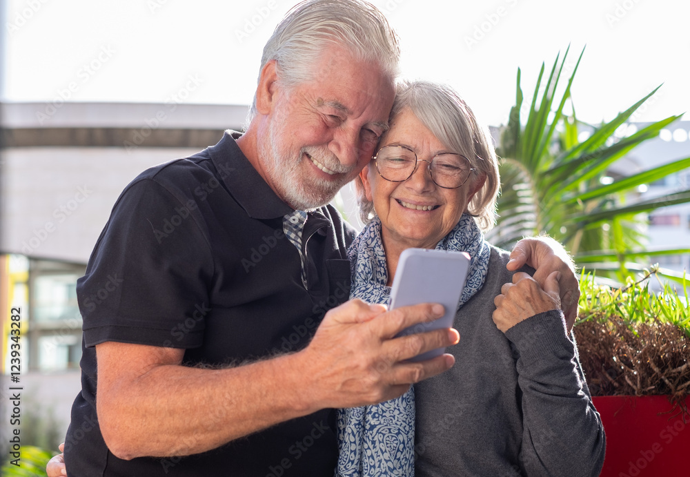Video call concept. Happy bonding loving mature senior retired couple using mobile phone for online webcam connection, enjoying carefree moments together with distant family Video call concept. Happy bonding loving mature senior retired couple using mobile phone for online webcam connection, enjoying carefree moments together with distant family