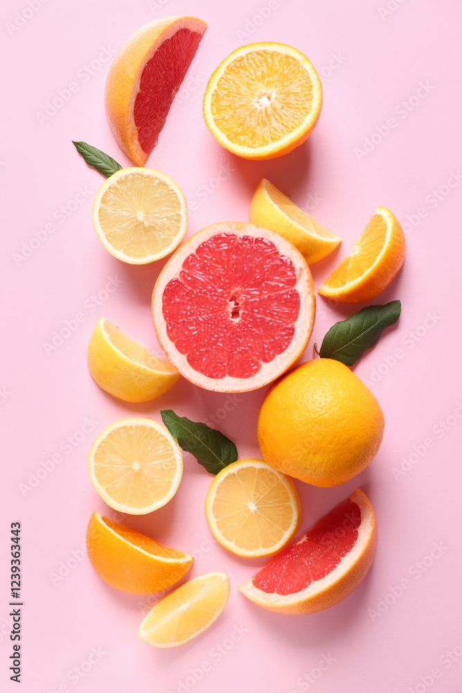 Different cut citrus fruits with leaves on pink background Different cut citrus fruits with leaves on pink background