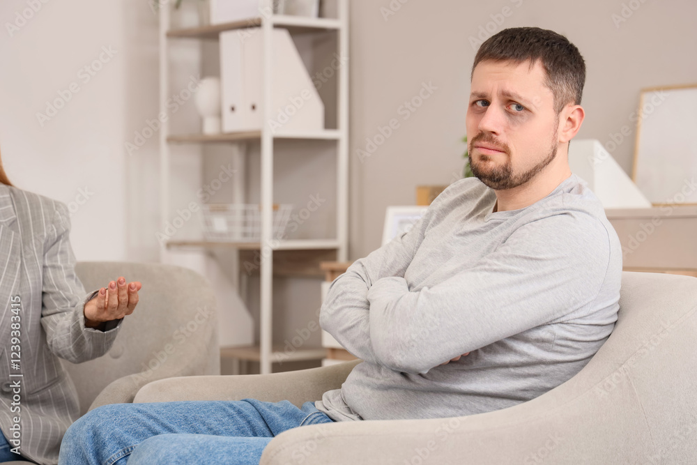 Sad male drug addict sitting in psychologist's office Sad male drug addict sitting in psychologist's office