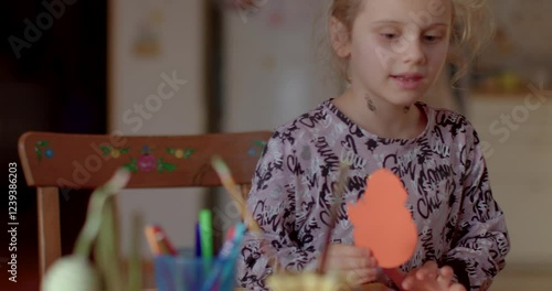 Preschool girl happy and sad. Creativity in festive activity. Inclusivity of participating in Easter crafts, celebrating personal expression and creativity. Autistic girl lifestyle portrait