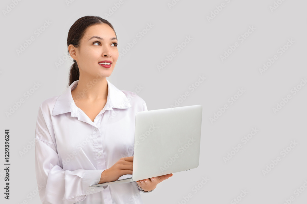 Young Asian businesswoman using modern laptop on white background Young Asian businesswoman using modern laptop on white background