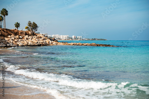 Serene Beach with Turquoise Waters and Rocky Shoreline photo