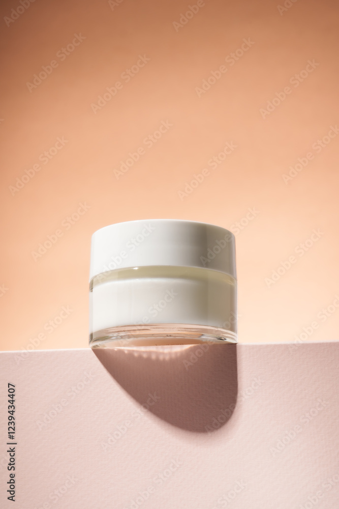Cream jar on podium with beige background.