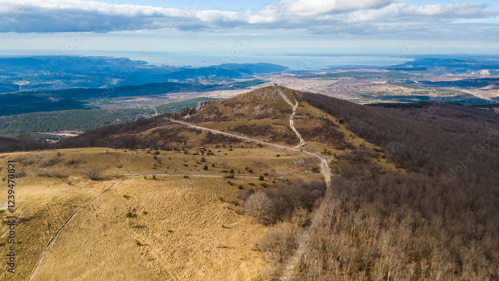 Fototapeta premium A breathtaking aerial drone view of Slavnik, one of Slovenia's most iconic peaks, standing at 1,028 meters above sea level. Located in the Karst region near the border with Croatia
