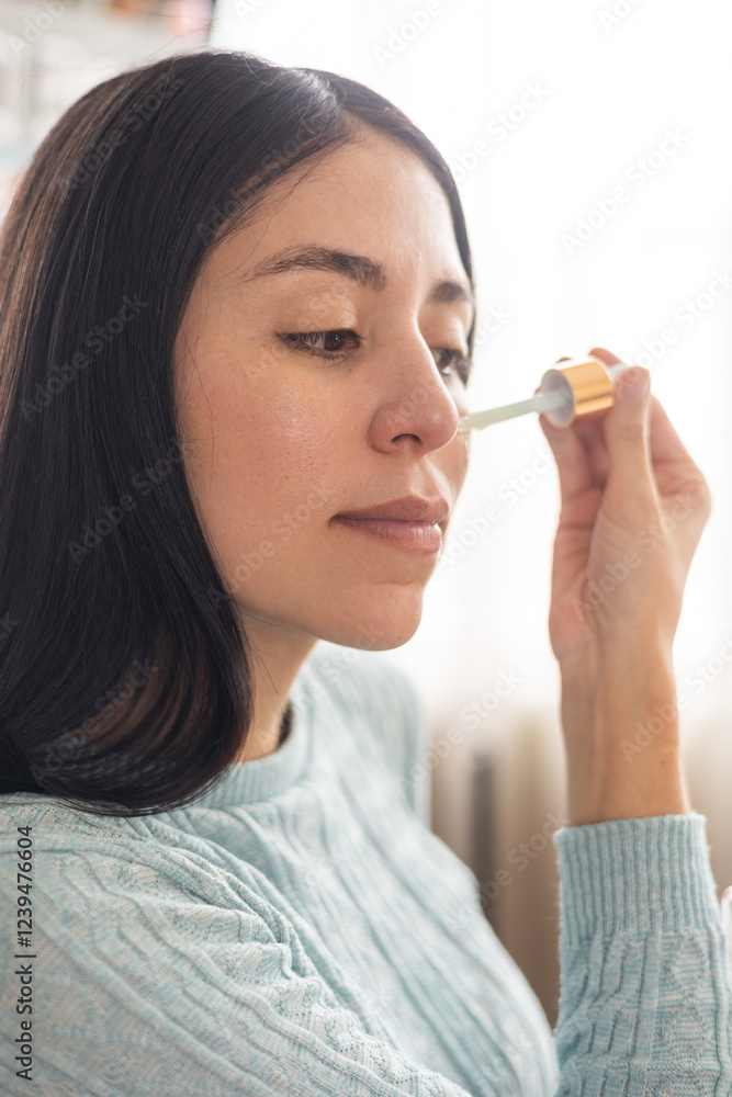 A woman applying moisturizing oil drops with a dispenser. Ideal for skincare, beauty, and self-care content, showing a nourishing and rejuvenating routine.