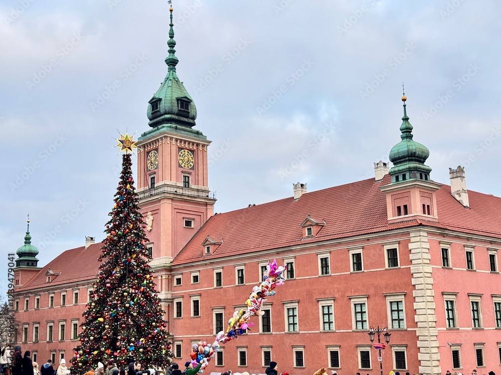 Fototapeta premium view of the big christmas tree in front of the castle in the old town of warsaw with its tower and clock on a cold december day 
