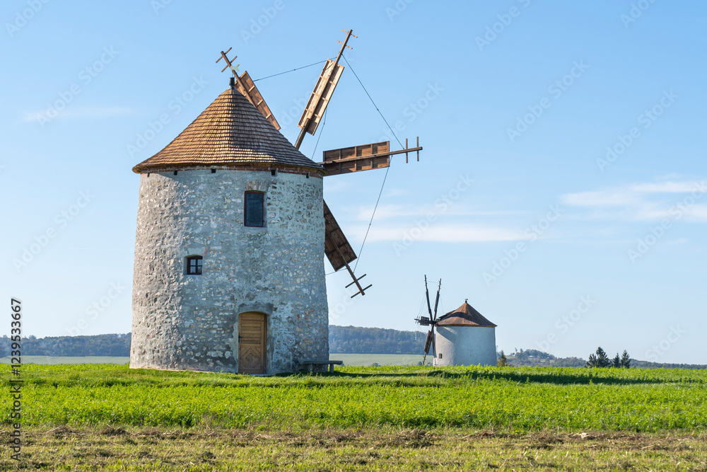 Rustic stone windmills in a grassy field Rustic stone windmills in a grassy field