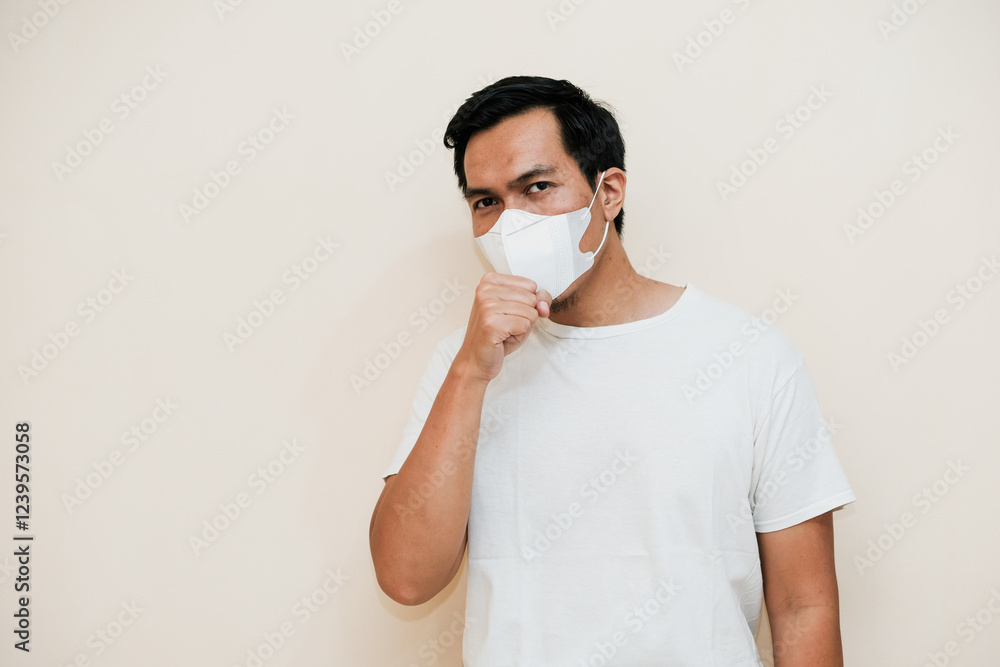 Southeast Asian man wearing hygienic mask and coughing. isolated over white background. Healthcare medical concept Southeast Asian man wearing hygienic mask and coughing. isolated over white background. Healthcare medical concept