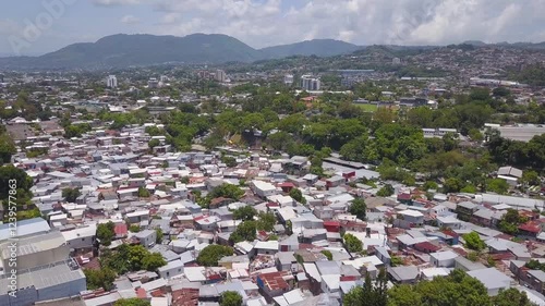 Slums, poverty area with shanty houses and favela in the middle of the city of San Salvador during daytime.