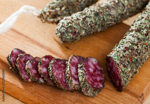 Obraz na plátně Fuet, traditional spanish dry cured sausage with fine herbs on wooden table