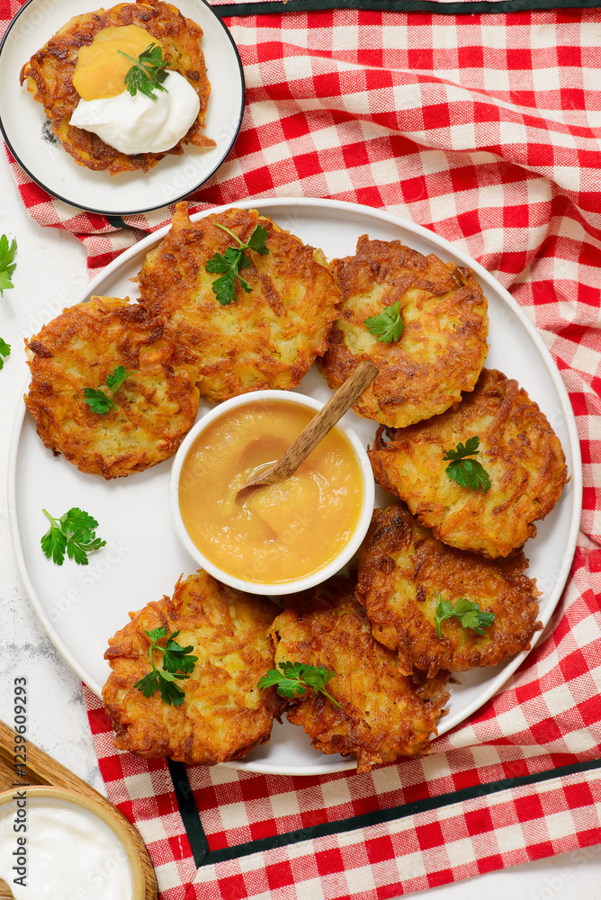 Traditional German potato latkes with applesauce and sour cream.selective focus Traditional German potato latkes with applesauce and sour cream.selective focus