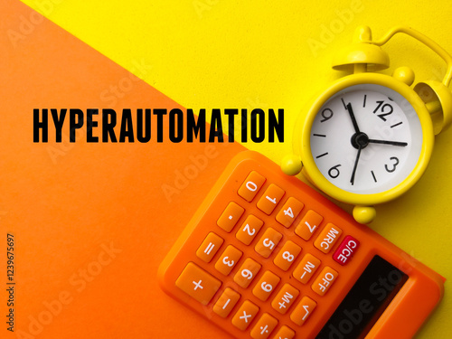 Calculator and alarm clock with the word HYPERAUTOMATION on a yellow and orange background.Business concept photo