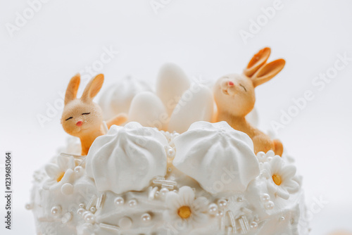 Airy pastries with Easter decor in light colors on a wooden table. Spring festive desserts. Catholic and Orthodox holidays table.Cute Bunny Decoration on Cake 