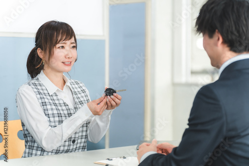 Wallpaper Mural 受付で車の鍵の受け渡しをする女性スタッフと顧客の男性
 Torontodigital.ca