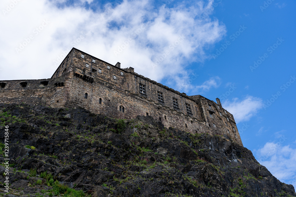 Edinburgh Castle's imposing stone walls climb a dramatic rock face under a brilliant blue sky. Edinburgh Castle's imposing stone walls climb a dramatic rock face under a brilliant blue sky.