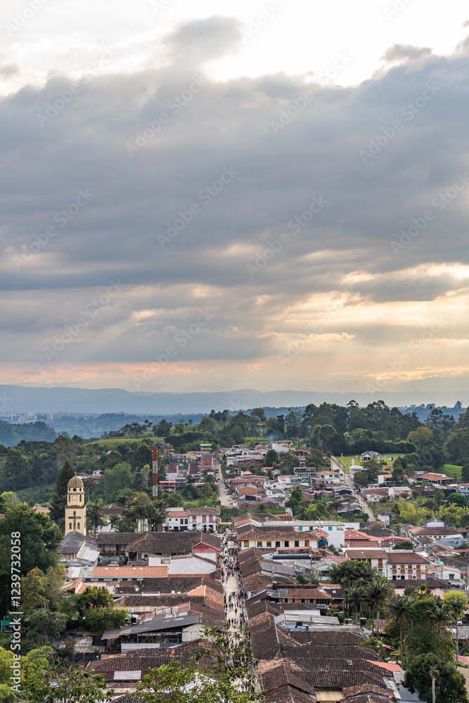 Naklejka premium Salento town at sunset in the mountains of Colombia. Aerial view of the houses and the main church. Busy place for tourism and traveling lifestyle.