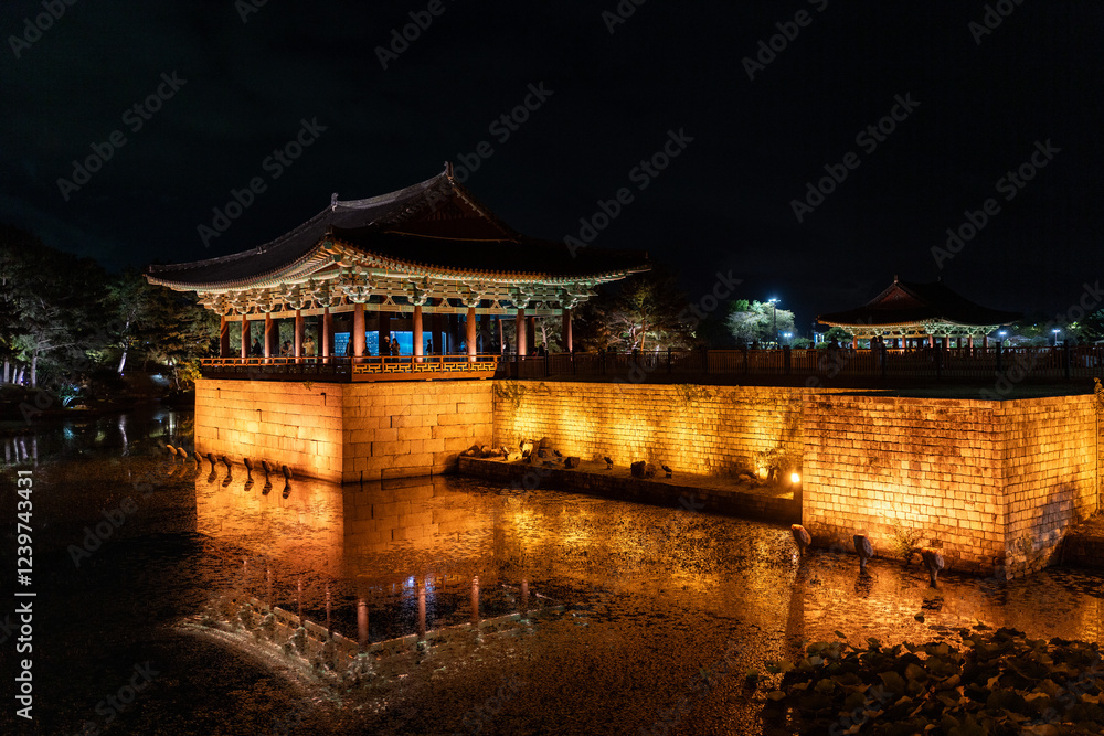 Obraz premium A stunning night view of Gyeonghoeru Pavilion in Korea, beautifully lit, reflecting on the calm water.