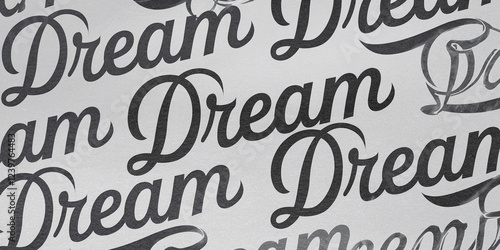 Handwritten 'Dream' in Black Cursive Script Repeated on Paper photo