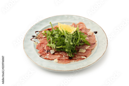 Delicious beef carpaccio with arugula, cheese, balsamic vinegar and lemon isolated on white