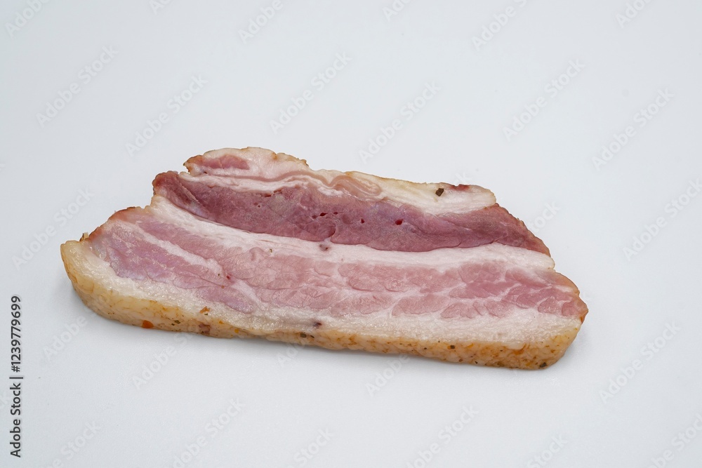 Pieces of salted lard with layers of meat on a white background. Sliced bacon. Pieces of salted lard with layers of meat on a white background. Sliced bacon.