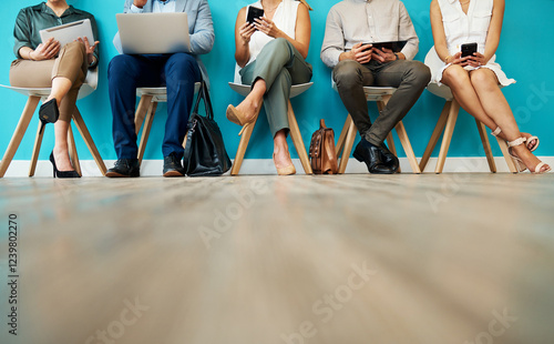 Obraz na płótnie Business people, legs and waiting room with technology for career opportunity, interview or job at office. Group, employees or candidates with laptop or phone in row for company info on mockup space w salonie