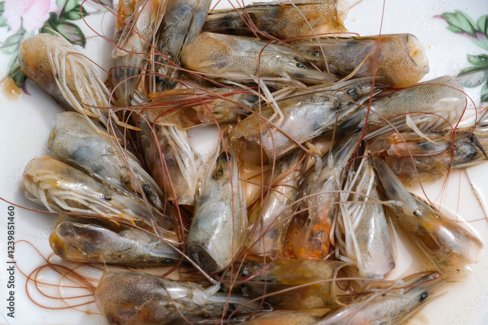 Closeup details of a pile of shrimp heads. The remains of cleaning shrimps leaving the shrimp heads. Backgrounds Fresh Shrimp. Ingredients for broth. Raw and fishy ingredients. Closeup details of a pile of shrimp heads. The remains of cleaning shrimps leaving the shrimp heads. Backgrounds Fresh Shrimp. Ingredients for broth. Raw and fishy ingredients.