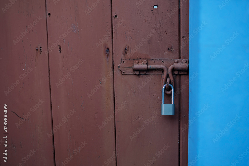 The brown wooden door is locked with a key. The brown wooden door is locked with a key.