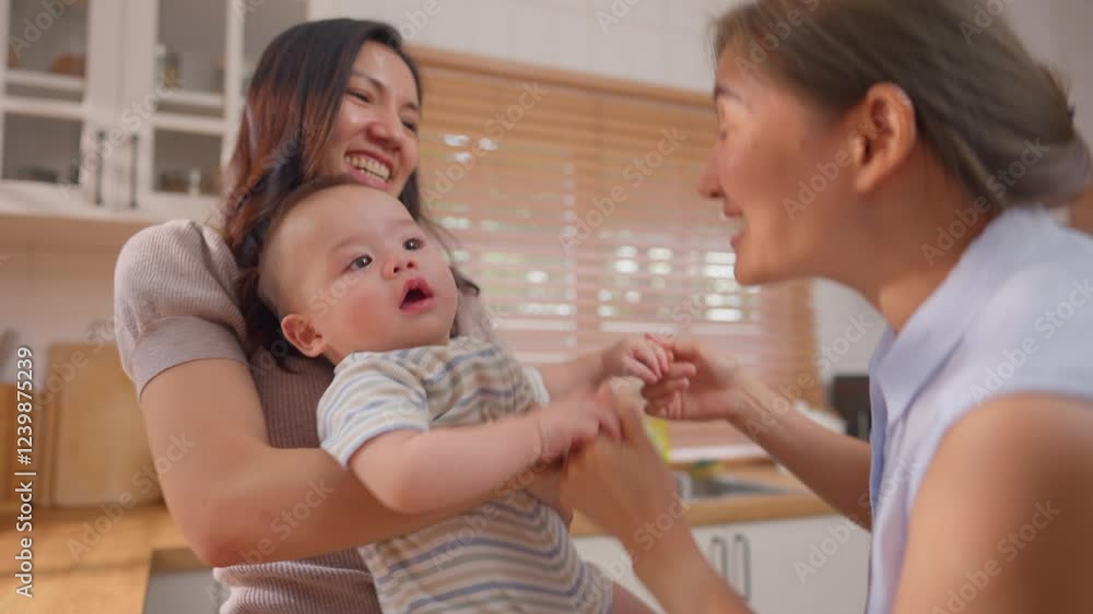 Asian lesbian couple lovingly caring for and raising their baby boy at home. Asian lesbian couple lovingly caring for and raising their baby boy at home.