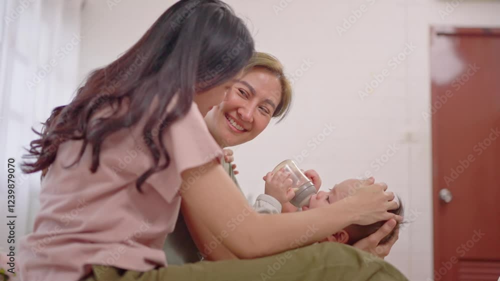 Asian lesbian couple caring for and raising their baby boy at home. Asian lesbian couple caring for and raising their baby boy at home.