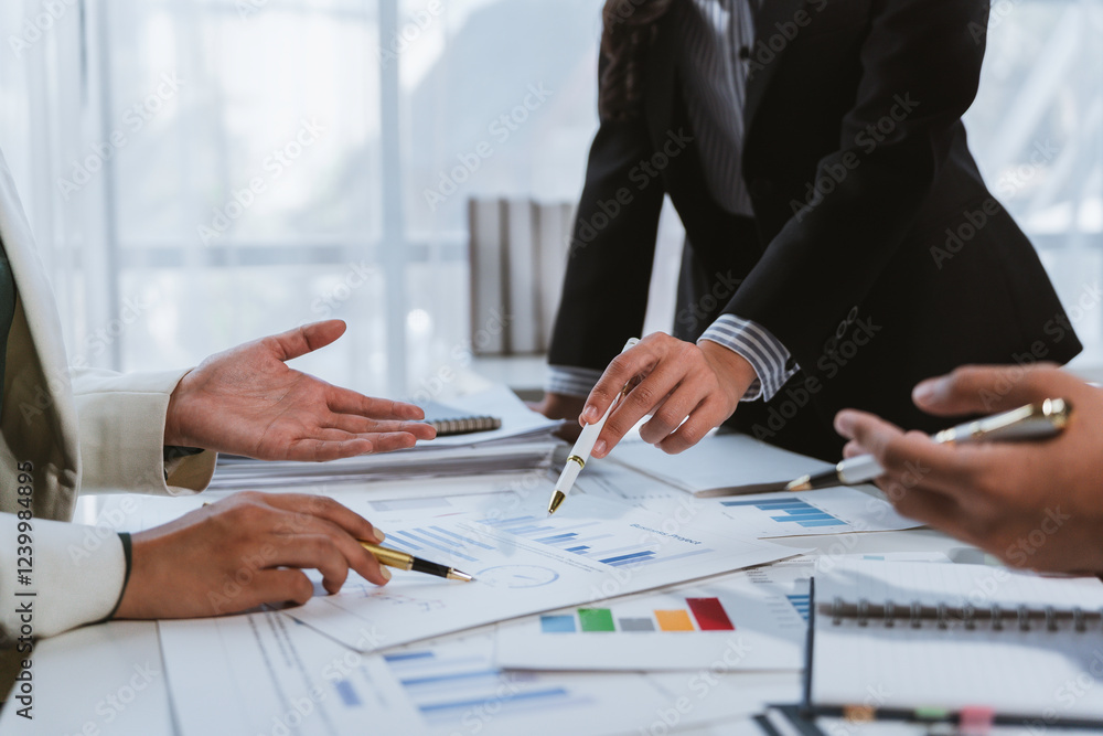 Business people analyzing marketing charts and graphs discussing company strategy Business people analyzing marketing charts and graphs discussing company strategy