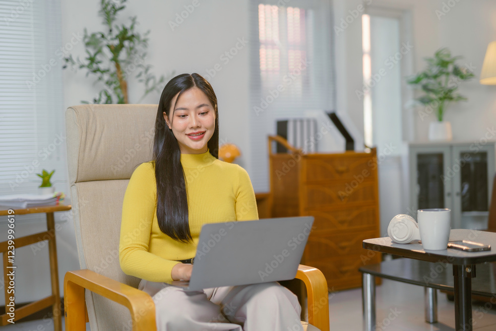Young Asian Freelancer Working From Home Using Laptop Young Asian Freelancer Working From Home Using Laptop