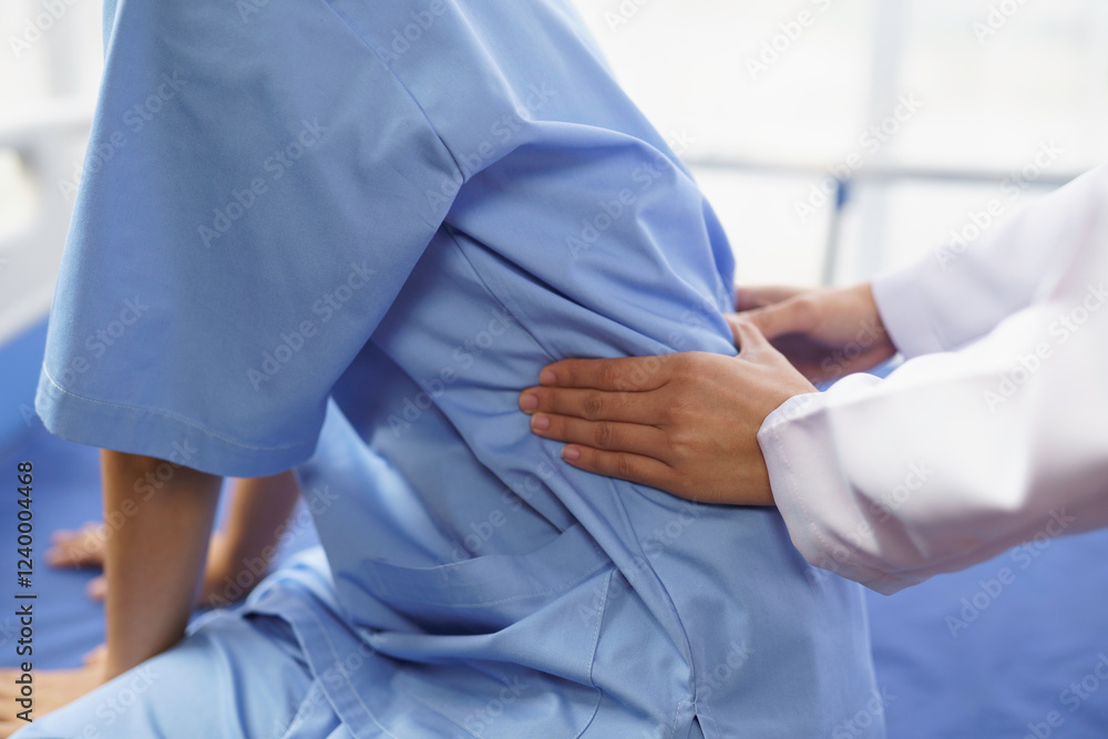 Doctor examining patient's back pain in hospital bed Doctor examining patient's back pain in hospital bed
