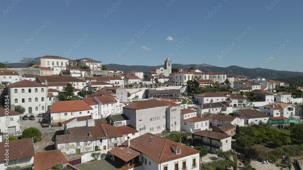 Aerial view of Penela a 1137 municipality of Portugal. Drone slowly ascending and camera tilting down showing the buildings and a church tower of the municipality. mountains in the background. Aerial view of Penela a 1137 municipality of Portugal. Drone slowly ascending and camera tilting down showing the buildings and a church tower of the municipality. mountains in the background.