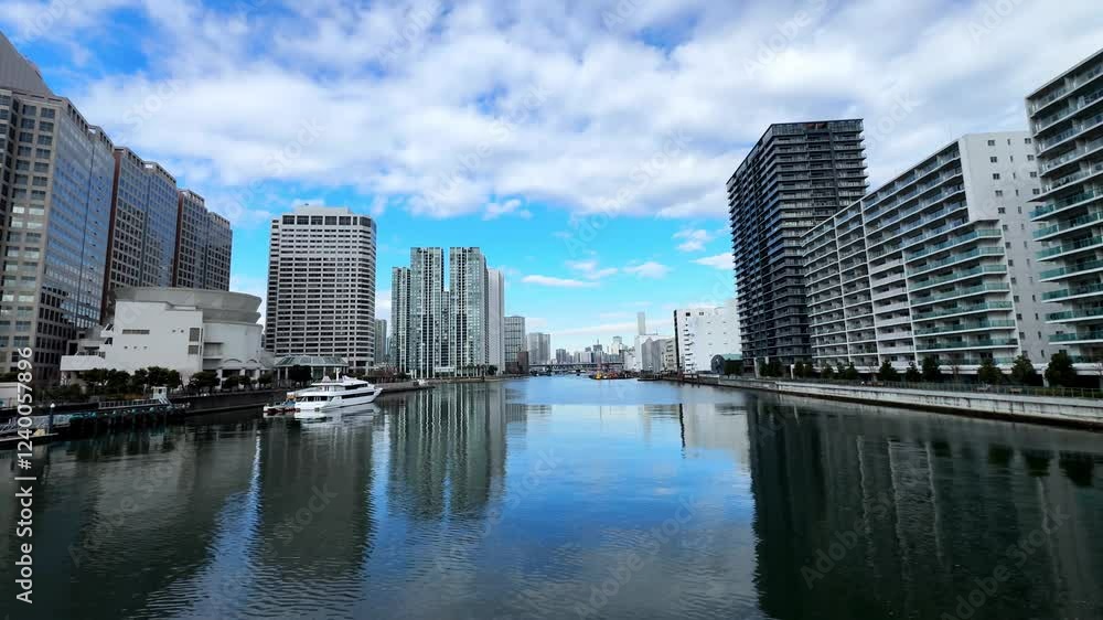 A calm riverside view of modern Tokyo with tall buildings and serene reflections A calm riverside view of modern Tokyo with tall buildings and serene reflections