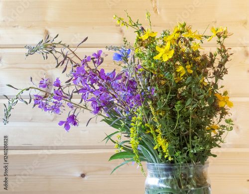 Flowers on a wooden background , medicinal plants in a bouquet, St. John's wort with sweet clover and Ivan tea photo