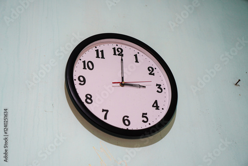 Wallpaper Mural A simple analog wall clock hanging on a light-green wall. The clock shows the time. Simple Wall Clock Showing Time Torontodigital.ca