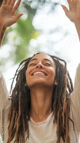 Joyful woman celebrating outdoors with raised arms in a sunny setting