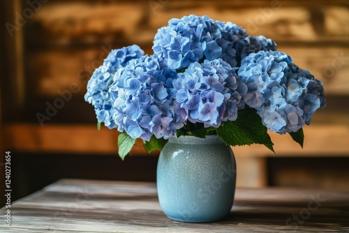 Bright blue flowers in a glass vase on a rustic wooden table indoors