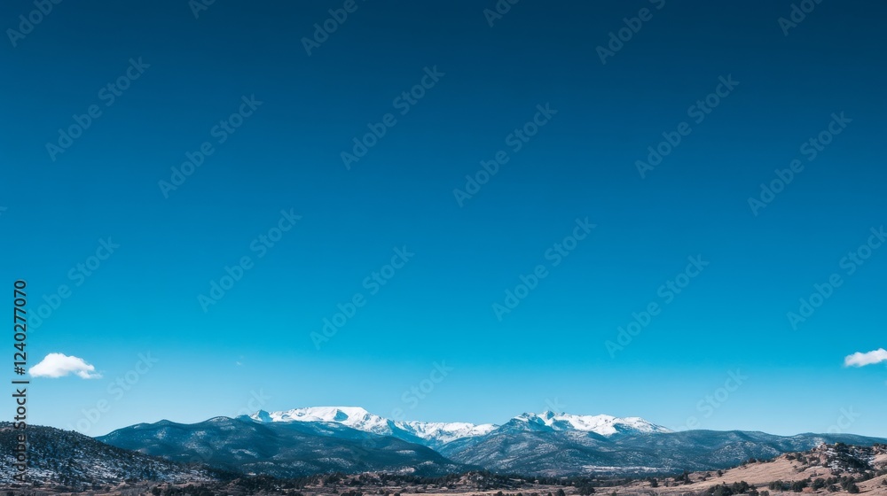 A vivid blue sky frames distant snowy mountains, embodying the majestic and expansive beauty of nature. A vivid blue sky frames distant snowy mountains, embodying the majestic and expansive beauty of nature.