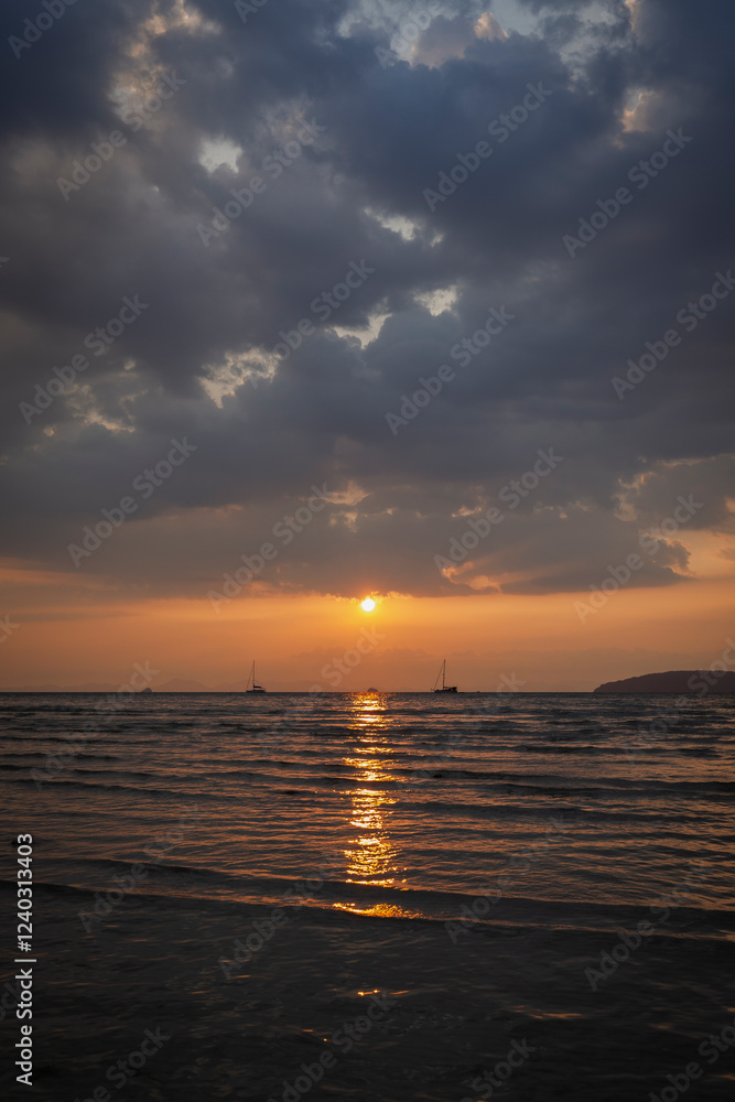 Naklejka premium Beautiful landscape of the Andaman Sea and cloudy sky during sunset at the Railay West Beach in Railay, Krabi, Thailand.