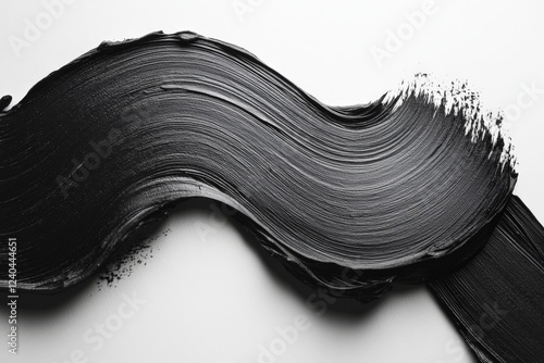 Black paint is smoothly swirled across a white surface showcasing artistic texture and contrast photo