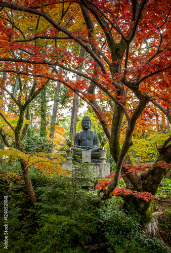 Obraz na płótnie A statue of Buddha in a traditional Japanese temple with autumn colours in Kyoto w salonie