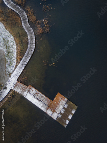 Aerial view of a beautiful pedestrian bridge over a frozen lake surrounded by serene winter landscape, Trakai, Lithuania. photo